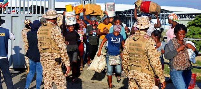 Soldados dominicanos hacen guardia mientras ciudadanos haitianos cruzan la frontera entre Quanamienthe (Haití) y Dajabón (República Dominicana), el 7 de marzo de 2024. Foto: Erickson Polanco. AFP